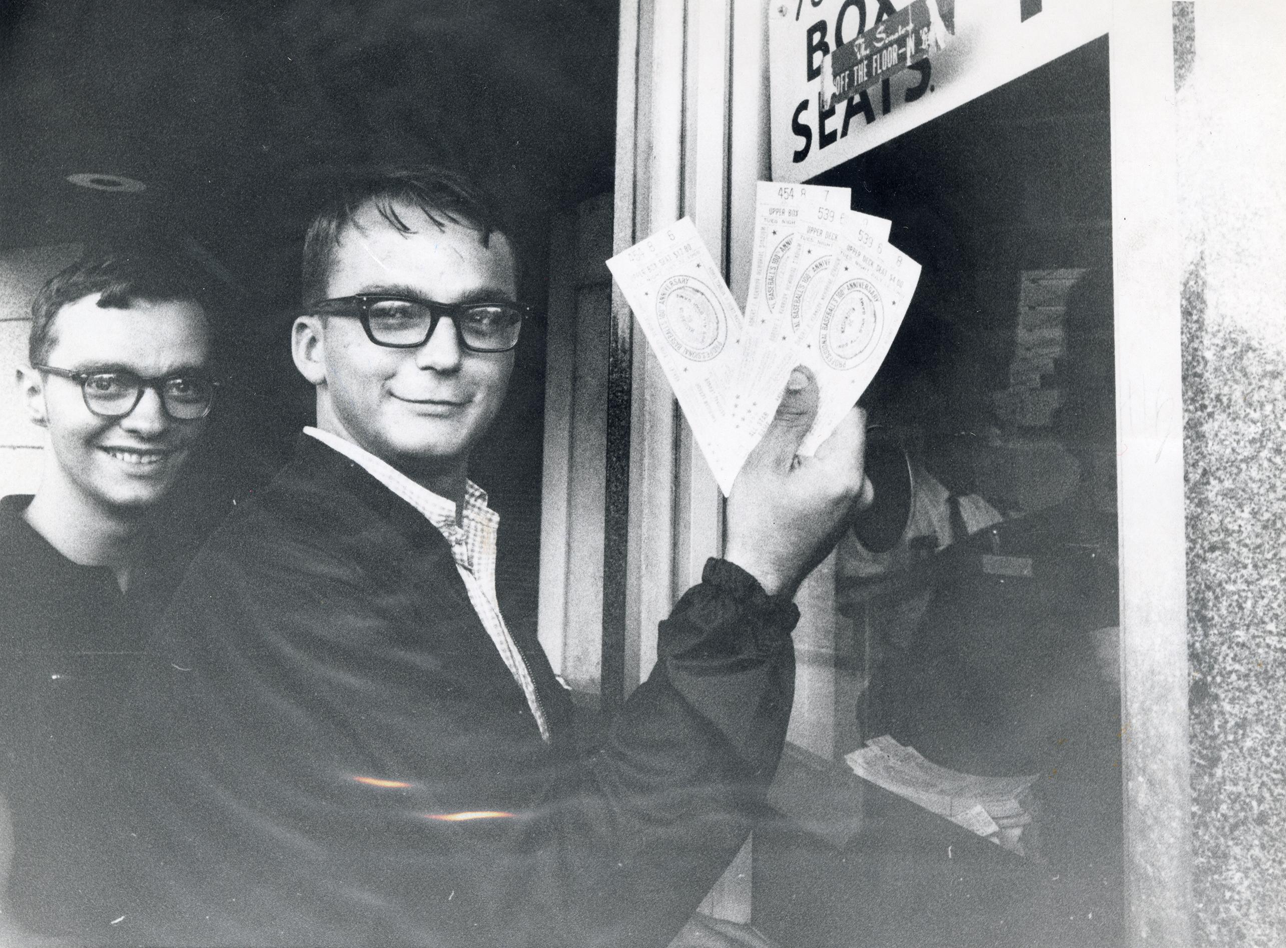 Two fans standing outside the RFK stadium ticket window holding tickets to the 1969 All Star game.