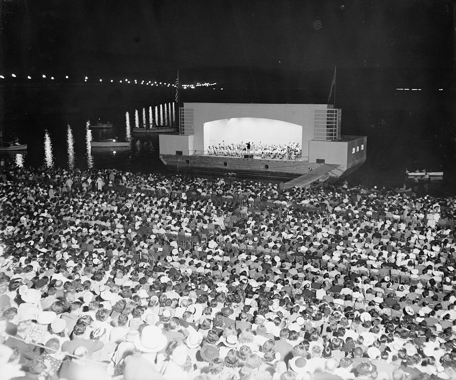 Hans Kindler conducts the NSO on the concert barge at the Watergate Amphitheatre in 1939.  (Photo Source: Library of Congress) https://www.loc.gov/pictures/item/hec2009013682/