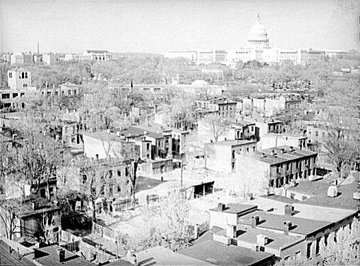 A view of Southwest from above. This is from pre-urban renewal circa 1939. Crowded streets full of buildings are in the foreground and the Capitol building is visible in the background. 