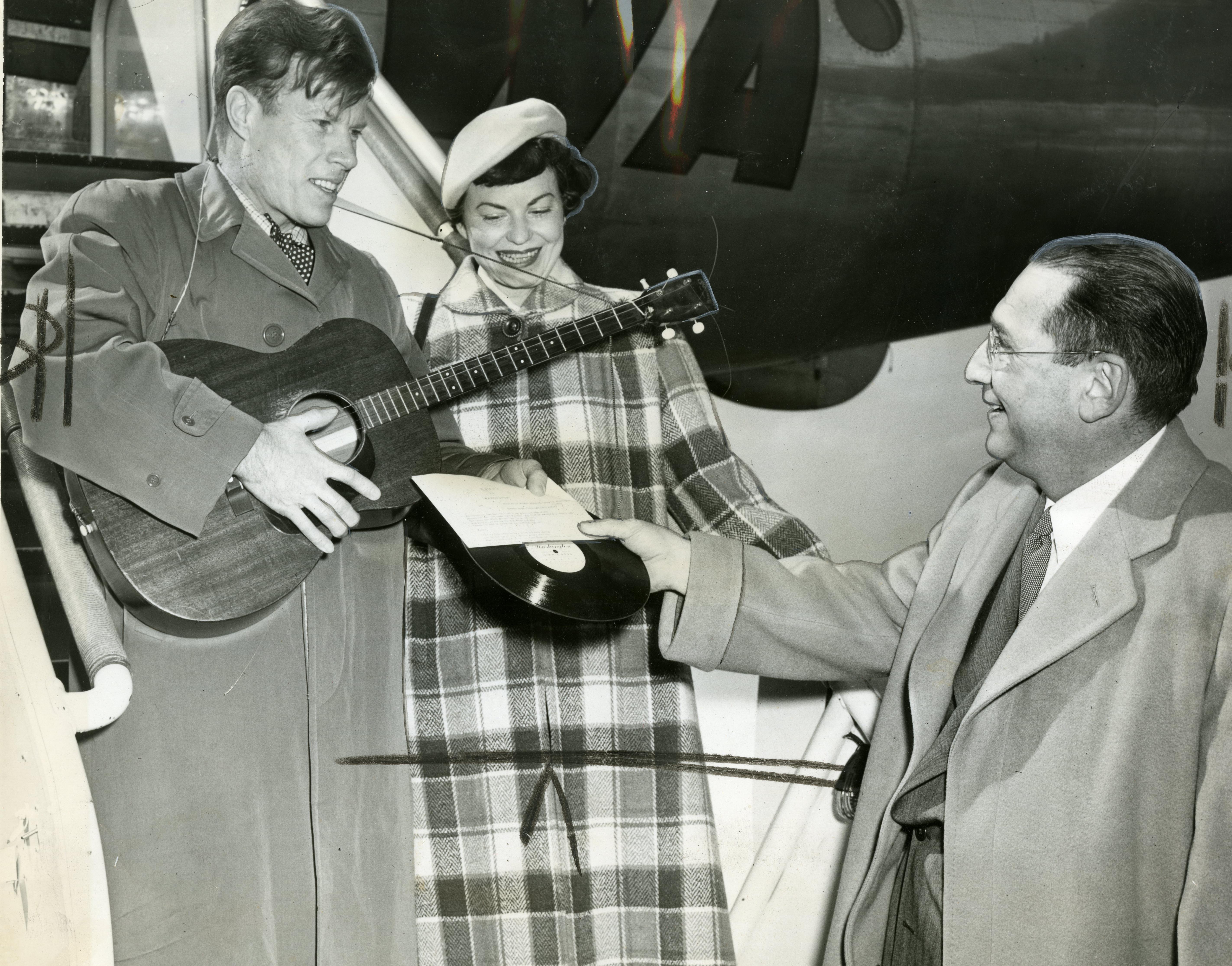 From left to right, Jimmie Dodd and his wife, Ruth, are presented with a record of "Washington" by James H. Simon.